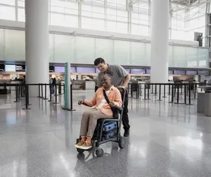 Woman in a wheelchair assisted by staff